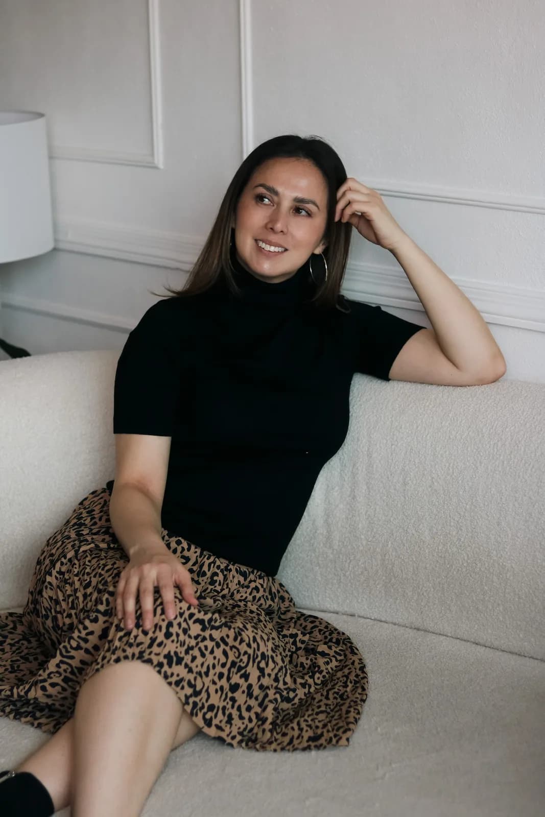 Jessica González sonriendo en un sofá claro